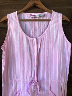 "Cutie patootie vintage 80's white and pink striped playsuit romper. Powder pink with white printed stripes and single stitched thread stripes. Short, mini dress length. Hand pockets! Cinch tie at the waist. 100% crepe feel cotton. Size medium. Has a looser, oversized fit. This thing is the best. I'm obsessed. Made by Gitano Measurements laying flat: fabric does not stretch. Length: Armpit to armpit: 20\" Waist: 18.5\" Hips: 21\" Shoulder to crotch: 30\" Inseam: 3\"" Retro Pink Summer Jumpsuits And Rompers, Retro Pink Jumpsuits And Rompers For Summer, Pink Retro Summer Jumpsuits And Rompers, Spring Striped Cotton Jumpsuits And Rompers, Striped Cotton Jumpsuits And Rompers For Spring, Pink Retro Jumpsuits And Rompers For Spring, Striped Sleeveless Jumpsuit For Loungewear, Striped Sleeveless Jumpsuits And Rompers For Loungewear, Sleeveless Striped Jumpsuits And Rompers For Loungewear