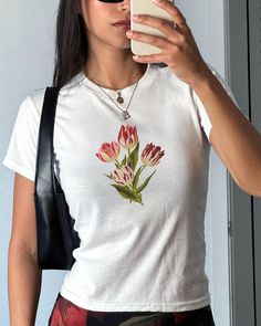 Florals for spring? Groundbreaking... Our tulip tee is ideal for pairing with denim for a laid back casual outfit, or with a floral maxi skirt for a more elevated look. These white t shirts are shrunken regular tees in the style of 90s and y2k baby tees so you can expect a classic crew neck t-shirt, but smaller! Swipe through the photos for our size guide :) 🍒 DETAILS 100% cotton Youth tees - these are small, shrunken t-shirts, not crop tops! Unisex Lightweight DTG - digitally printed  Ribbed c Fitted Floral Print T-shirt For Spring, Fitted T-shirt For Spring, Fitted White T-shirt With Floral Print, Trendy Tops With Plant Print For Spring, Trendy Plant Print Tops For Spring, Trendy Spring Tops With Plant Print, Fitted Floral Print Graphic Tee, Fitted Floral Print T-shirt With Crew Neck, Floral Print Short Sleeve T-shirt For Spring