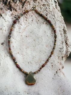 The colors in the gemstones that are mined out of the Red Creek area in China are so vibrant and beautiful, I never get tired of them. This pendant is a lovely example of the kinds of colors we frequently see in red creek jasper. Tribal in tone and energy, this strong 20" necklace is finished with a decorative toggle clasp. N227 Jasper Beaded Necklaces With Natural Stones For Gift, Gift Jasper Beaded Necklaces With Natural Stones, Earthy Jasper Gemstone Beads Jewelry, Earthy Jasper Jewelry With Natural Stones, Bohemian Jasper Necklace With Polished Beads, Artisan Jasper Beaded Necklaces As Gifts, Jasper Gemstone Beaded Necklaces As Gift, Jasper Gemstone Beaded Necklace As Gift, Earthy Jasper Beaded Necklace As Gift