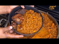 someone is holding a pan full of rice and meat on top of the stovetop