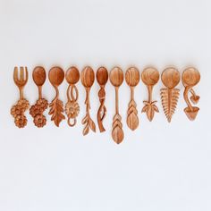 a row of wooden spoons with different designs on them