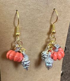 White or orange pumpkins with silver acorns and pine cones, with silver earring hooks | Pumpkin With Acorn And Pine Cone Earrings Pine Cone Earrings, Handmade Dangle Earrings, Earrings Handmade Dangle, Pumpkin Orange, Earring Hooks, Pine Cone, Silver Earring, Pine Cones, Pumpkins