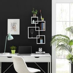 a white desk topped with a laptop computer next to a potted plant and window