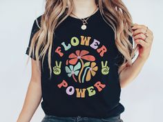 Step into a time of peace and love with this "Flower Power"  t-shirt. Featuring vibrant groovy flowers, peace sign, and the "Flower Power" slogan in bold 70s font, this shirt is a tribute to the carefree spirit of the 1970s. Perfect for those who embrace the vintage vibe and spread positive energy, this tee is ideal for festivals, casual outings, or simply celebrating your inner hippie. Let the world know you're all about peace, love, and flowers with this eye-catching retro design! This design Multicolor Hippie T-shirt With Letter Print, Hippie Multicolor Letter Print T-shirt, Groovy Multicolor Letter Print T-shirt, Flower Power Shirt, 70s Font, Groovy Flowers, 1970s Style, Hippie Flowers, 1970s Fashion