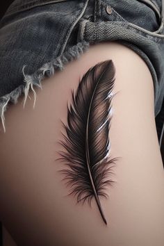 a woman's thigh with a black feather tattoo on it