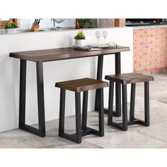 a kitchen table with two stools next to it and an oven in the background