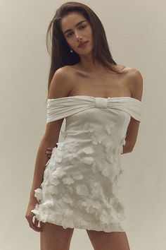 The BHLDN Off-The-Shoulder 3D Floral Mini Dress features exquisite floral detailing and a romantic silhouette, making it a stunning choice for any celebration. | Off-The-Shoulder 3D Floral Mini Dress by BHLDN in White, Women's, Size: Smallmall, Polyester/Cotton/Nylon at Anthropologie Bridal Reception Mini Dress, After Party Bridal Dress, Romantic Dress Aesthetic, White Dress Engagement Pictures, Aesthetic Background White, Hoco Dresses With Sleeves, Background White Aesthetic, White Aesthetic Background, Dress White Background