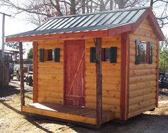 a small wooden cabin with a metal roof