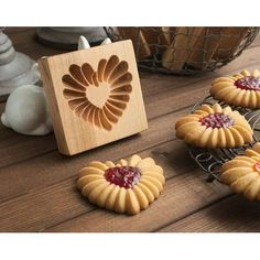 some cookies are sitting on a table next to a wooden block with the shape of a heart