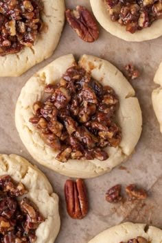 several pecan cookies are arranged on a baking sheet with pecans in the middle