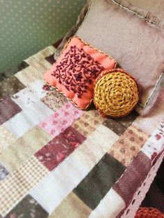 two decorative pillows sitting on top of a patchwork quilted bedspread,