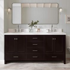 a bathroom vanity with two sinks and a large mirror above it, in front of a toilet