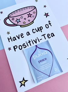 a cup of positivi - tea next to a card with the words have a cup of positivi - tea on it