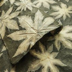 a leaf that is laying on top of a bed sheet with leaves all over it