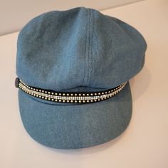 a blue hat with silver beads on it