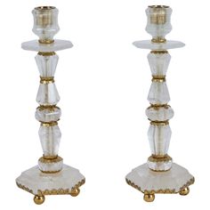 two clear glass candlesticks with gold accents