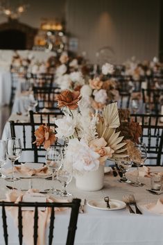 the tables are set with white and brown flowers