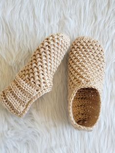 a pair of crocheted slippers sitting on top of a white rug