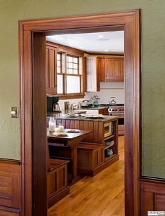 an open door leading to a kitchen with wooden cabinets