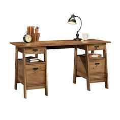 a wooden desk with two drawers and a lamp