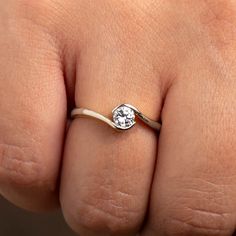 a woman's hand with a diamond ring on top of her finger, showing the band