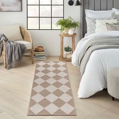 a bed room with a neatly made bed and a rug on the floor next to it