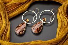 Orange-red Ocean Jasper teardrops are featured in a sterling silver setting and accented with a small 6mm citrine. The backs of the earrings have a stamped southwestern element. Sterling silver ear wires are added for easy on, easy off. These earrings were given a charcoal colored patina to highlight the details, then polished to a shine. Details: -Earrings are ~2.5 inches long from the ear wire -Hoop is 1 inch wide Ready to ship! This item will ship within 3 business days of purchase. Thanks fo Red Ocean, Jasper Earrings, Bold Jewelry, Rising Sun, Sterling Silver Hoop Earrings, Ocean Jasper, Dainty Earrings, Sterling Silver Hoops, Circle Earrings