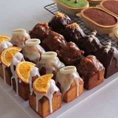 there are many different types of deserts on the trays with orange slices and candies