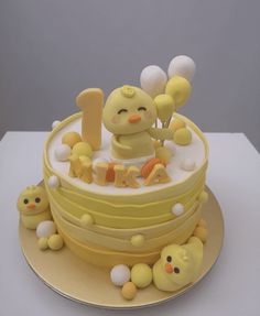 a cake with yellow frosting and white icing on the top is decorated with an image of a baby chick