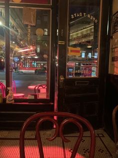 a red chair sitting in front of a store window