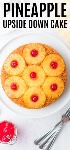 a pineapple upside down cake on a white plate next to some forks and spoons