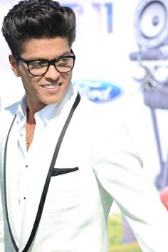 a man in a white suit and black glasses