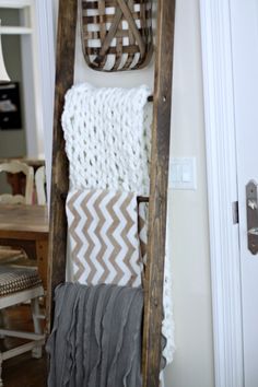 an old ladder is used as a blanket rack