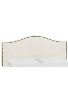 an upholstered headboard with white linen