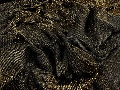 black and gold fabric with small dots on the top, as if it were sequins