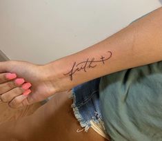 a woman's arm with the word faith tattooed on it