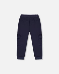 Our Fleece Sweatpants with Cargo Pockets Navy can be mixed and matched with any top to create endless outfits! Super soft in cotton/poly fleece, these sweatpants feature a ribbed waistband with a drawstring, rib knit ankles with a logo label at the hem, vertical on seam pockets for his hands, and side cargo pockets with velcro flaps. Drawstring waist sweatpant Side cargo pockets Vertical on seam pockets 80% Cotton, 20% Polyester Fits true to size From 2 years to 12 years Fleece Pants With Elastic Cuffs For Winter, Winter Fleece Pants With Elastic Cuffs, Blue Joggers With Pockets For Fall, Winter Navy Bottoms With Pockets, Casual Winter Playwear Pants, Navy Bottoms With Pockets For Winter, Blue Fleece Joggers With Pockets, Blue Fleece Sweatpants With Pockets, Navy Joggers With Pockets For Loungewear