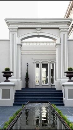 an entrance to a house with steps leading up to the front door and water feature