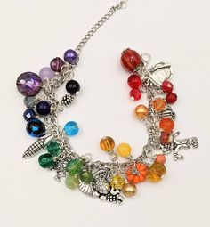 "- Autumn Charm Bracelet Stainless Steel Chain is adjustable from 6.5\" - 9\" with a lobster claw closure and extension chain The bracelet links are filled with a rainbow of glass and gem stone beads and crystals - really pretty. Mixed between the beads and gemstones are autumn themed silver and enamel charms. This is a great gift for anyone who loves the quirky symbols and bright colors of fall. I make these as they are ordered, so the processing time is 4 days. Your bracelet will be carefully Rainbow Metal Jewelry For Jewelry Making, Metal Beaded Dangle Charm Bracelet, Bohemian Multicolor Metal Charm Bracelet, Bohemian Style Multicolor Metal Charm Bracelet, Adjustable Rainbow Jewelry With Lobster Clasp, Adjustable Metal Crystal Bracelet With Charms, Multicolor Beaded Metal Charm Bracelet, Adjustable Crystal Jewelry With Charms, Adjustable Multicolor Crystal Bracelet