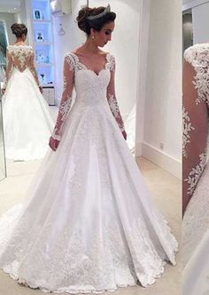 the back of a wedding dress with long sleeves and lace on it, in front of a mirror