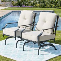 two chairs sitting on top of a rug next to a pool