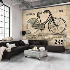 a living room with a couch, coffee table and large wall mural in the background