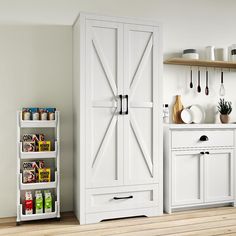 a kitchen with white cupboards and shelves filled with spices, condiments and utensils