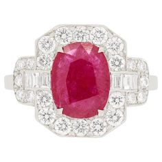 An entrancing red ruby, weighing 1.50 carat, takes centre stage in this marvellous vintage cluster ring. It has been mounted in the ring with four talon claws. The grand halo surrounding is composed with a combination of brilliant cut diamonds and baguette cut diamonds. The round brilliants combine to 0.84 carats and the baguettes total to 0.16 carats. They are all of excellent quality, being F in colour and VS in clarity. The cluster ring has been entirely made of 18ct white gold with cut out patterns, pleasingly decorating the gallery. Gemstone: Ruby Stone Shape: Oval Carat Weight: 1.50 Metal: 18ct White Gold Age: 1960s Size: N Vintage Cluster Ring, Centre Stage, Baguette Cut Diamond, Ruby Stone, Ruby Diamond, Diamond Cluster Ring, Red Ruby, Diamond Cluster, Cluster Ring