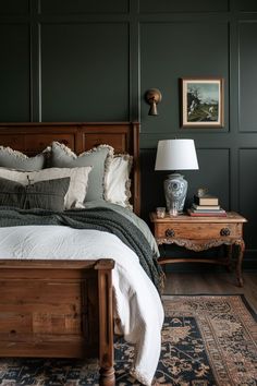 a bedroom with dark green walls and white bedding, two nightstands on either side