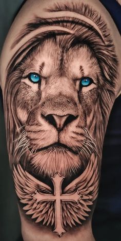 a man's arm with a lion tattoo on it and blue eyes in the center