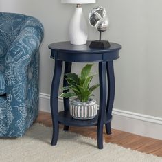 a blue end table with a plant on top and a lamp next to it in a living room