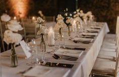 the table is set with white flowers and candles