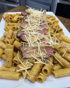 a white plate topped with pasta and meat