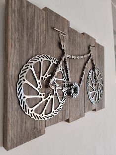 a wooden wall hanging with two bikes on it's sides and a necklace holder attached to the side